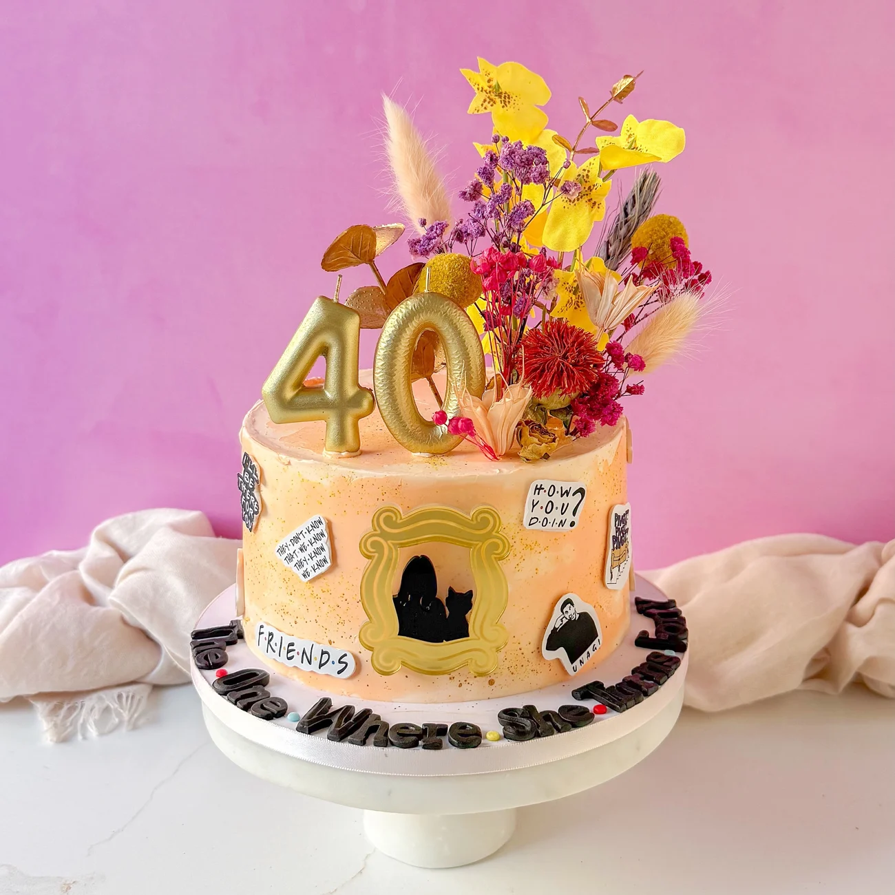 Nehla’s floral fortieth birthday cake, decorated with personalized details and gold numerals